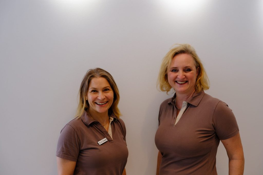 Zwei lächelnde Frauen, beige Shirts