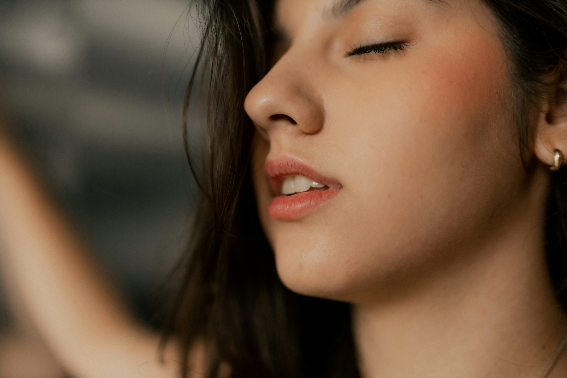 A woman closes her eyes in a peaceful moment.
